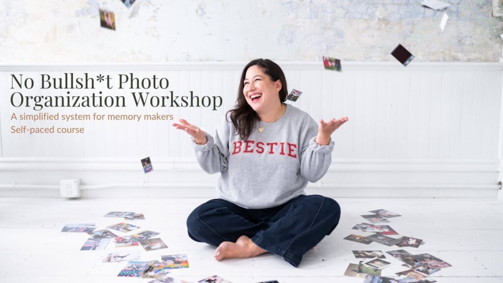 Kiera Liu throwing photos on floor wearing a bestie sweatshirt to symbolize ditching overwhelm of digital photos. 