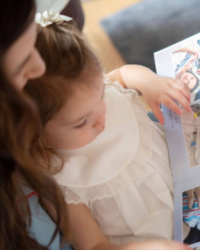 coralee dixon looks at shortcake album with daughter on her lap