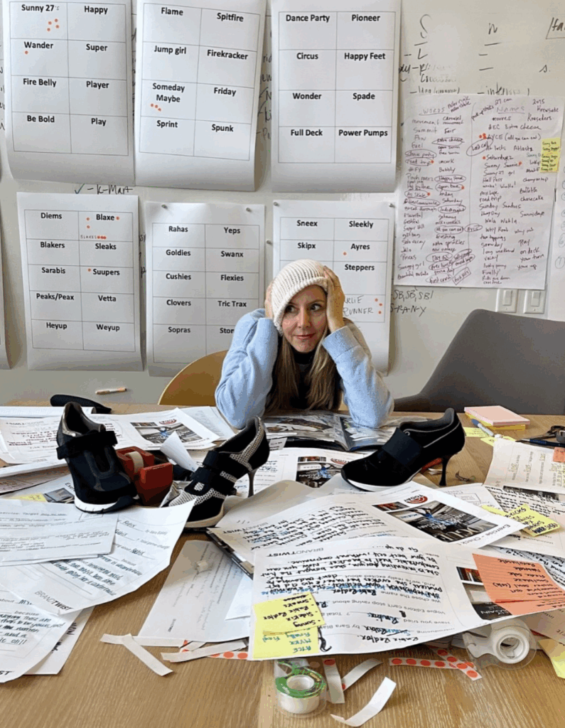 sara blakely instagram post wearing hat in office covered with papers with names written on them while she tried to name her company Spanx.