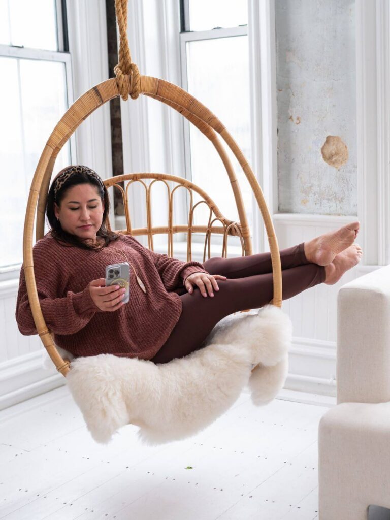 kiera liu in a floating egg chair while focused on backing up her camera roll